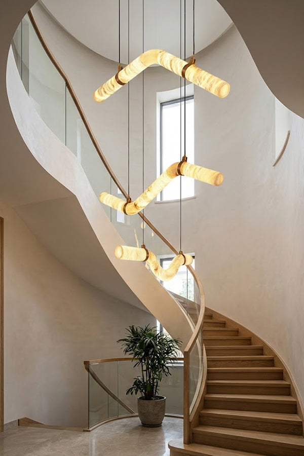 Multiple undulating alabaster tubes in a spiral staircase | Alabaster, Brass | High-ceiling void installation view | Samu Lamp