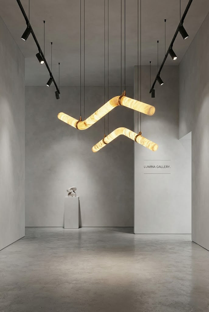 Undulating alabaster tube chandelier in minimalist gallery | Alabaster, Brass | Artistic installation over a pedestal | Samu Lamp