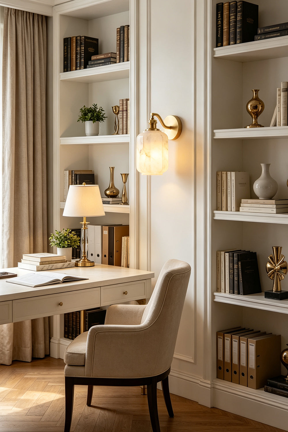 Cordelia Scalloped Alabaster Wall Sconce | Natural Alabaster and Brushed Brass | Styled in a sophisticated home office study next to white built-in library bookshelves and a desk | Samu Lamp