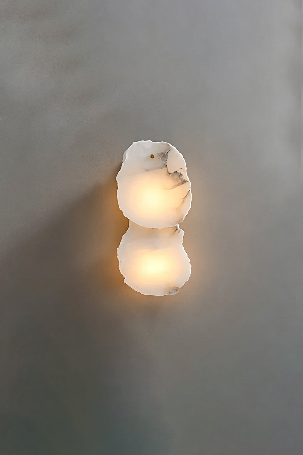 Corin Alabaster Wall Sconce featuring glowing alabaster cylinder design with brass accents.