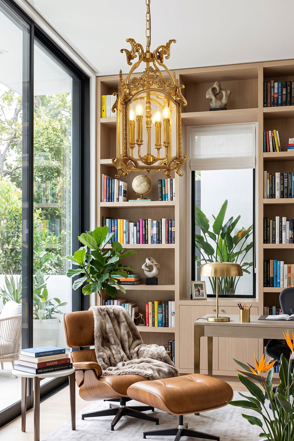 Corwin Glazed Brass Pendant Light illuminating a modern reading nook with bookshelves and a stylish armchair.