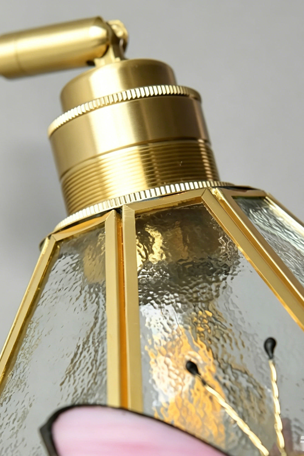 Cynthia Butterfly Articulated Wall Lamp | Stained Glass, Metal, Wood | Detailed close-up showing the polished gold brass socket cap connection sitting atop the clear textured hammered glass shade | Detail shot | Samu Lamp