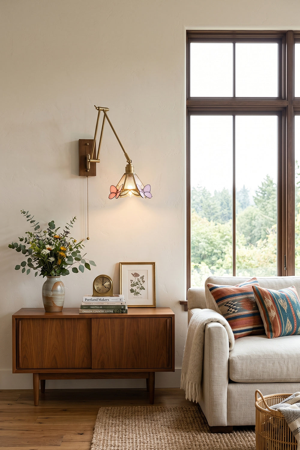 Cynthia Butterfly Articulated Wall Lamp | Stained Glass, Metal, Wood | Providing warm accent light above a mid-century wooden sideboard credenza next to a cream fabric sofa | Samu Lamp