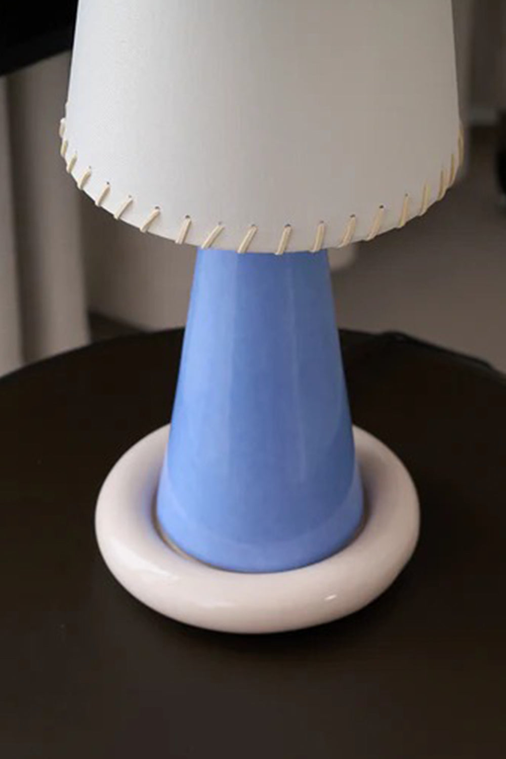 Dolce Ribbon Ceramic Table Lamp featuring a periwinkle blue ceramic stem and cream-pink donut ring base.