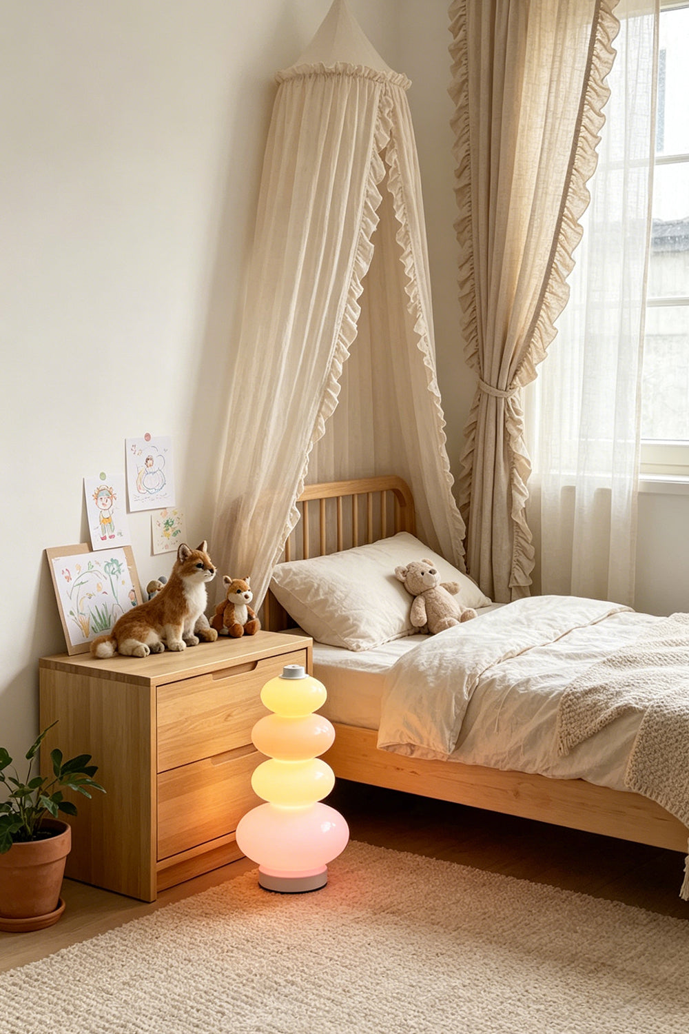 Dolce Stacked Pastel Glass Table Lamp | Glass, Metal | Providing a soft whimsical nightlight on a wooden bedside table in a cozy children's bedroom with a bed canopy | Samu Lamp