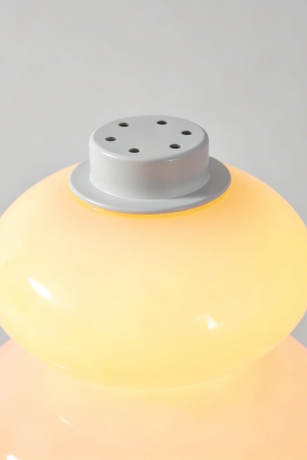 Dolce Stacked Pastel Glass Table Lamp | Glass, Metal | Top-down macro view of the pastel yellow top tier and the white matte cap with ventilation holes | Detail shot | Samu Lamp