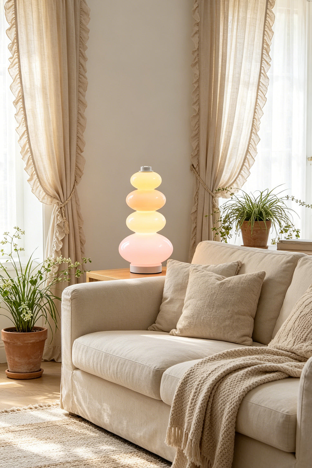 Dolce Stacked Pastel Glass Table Lamp | Glass, Metal | Illuminating a serene living room corner from a side table next to a comfortable beige fabric sofa | Samu Lamp