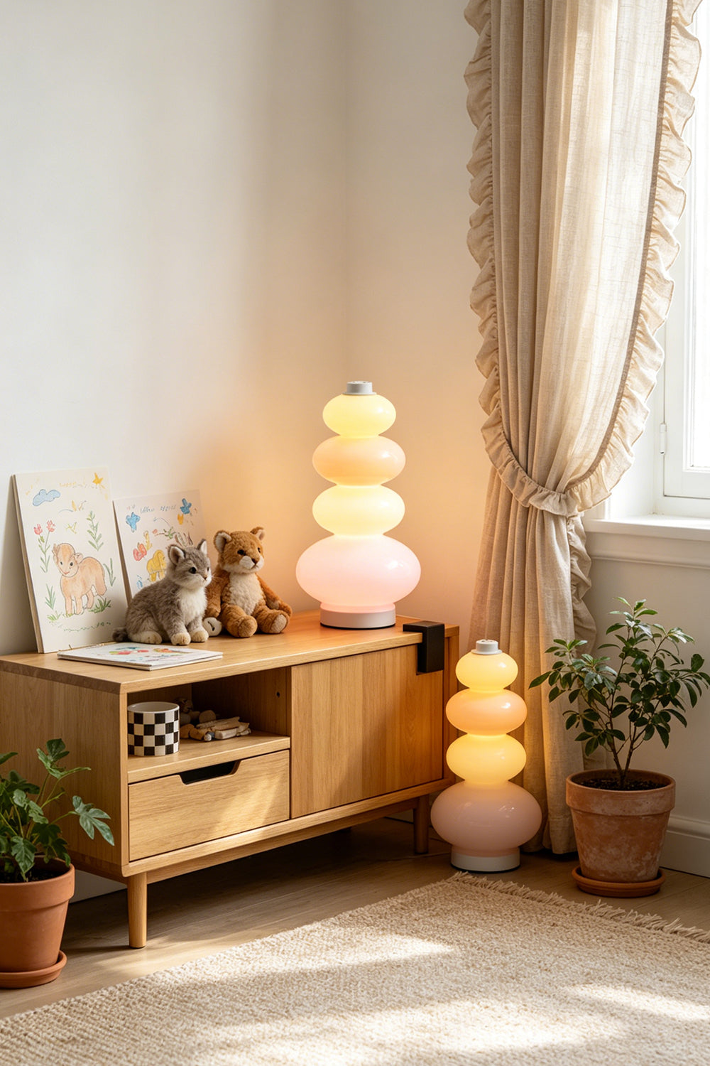 Dolce Stacked Pastel Glass Table Lamp | Glass, Metal | Displayed on a rustic wooden credenza next to a sunlit window with flowing lace curtains | Samu Lamp