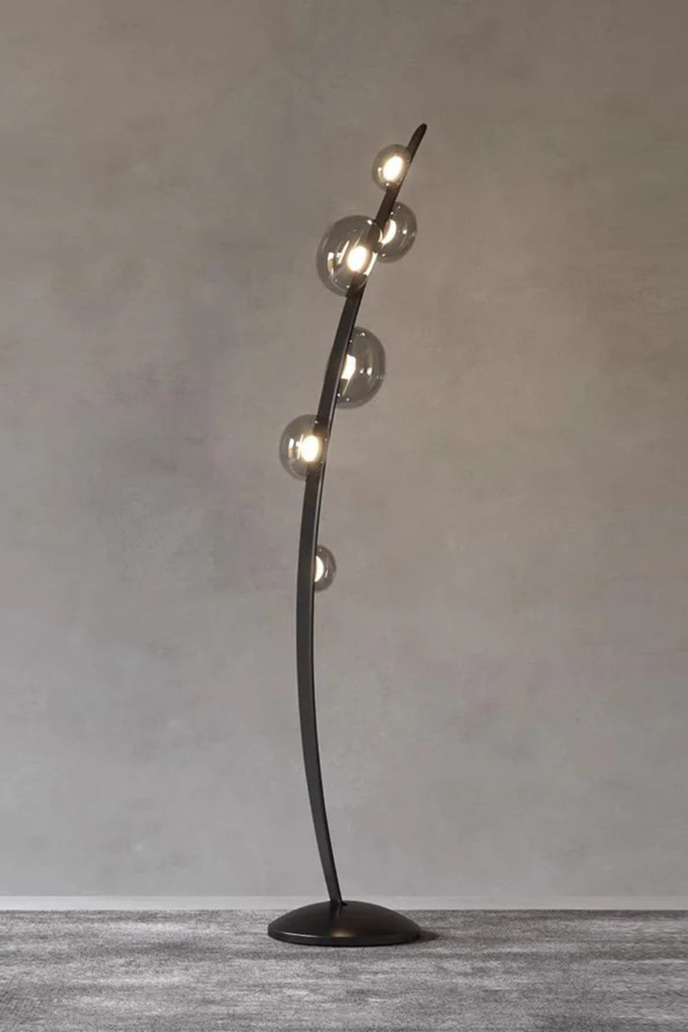 Drosia Dewdrop Floor Lamp | Glass, Metal | Studio view of the unlit organic black floor fixture showcasing its sculptural curved form and clear glass spheres against a grey backdrop | Samu Lamp