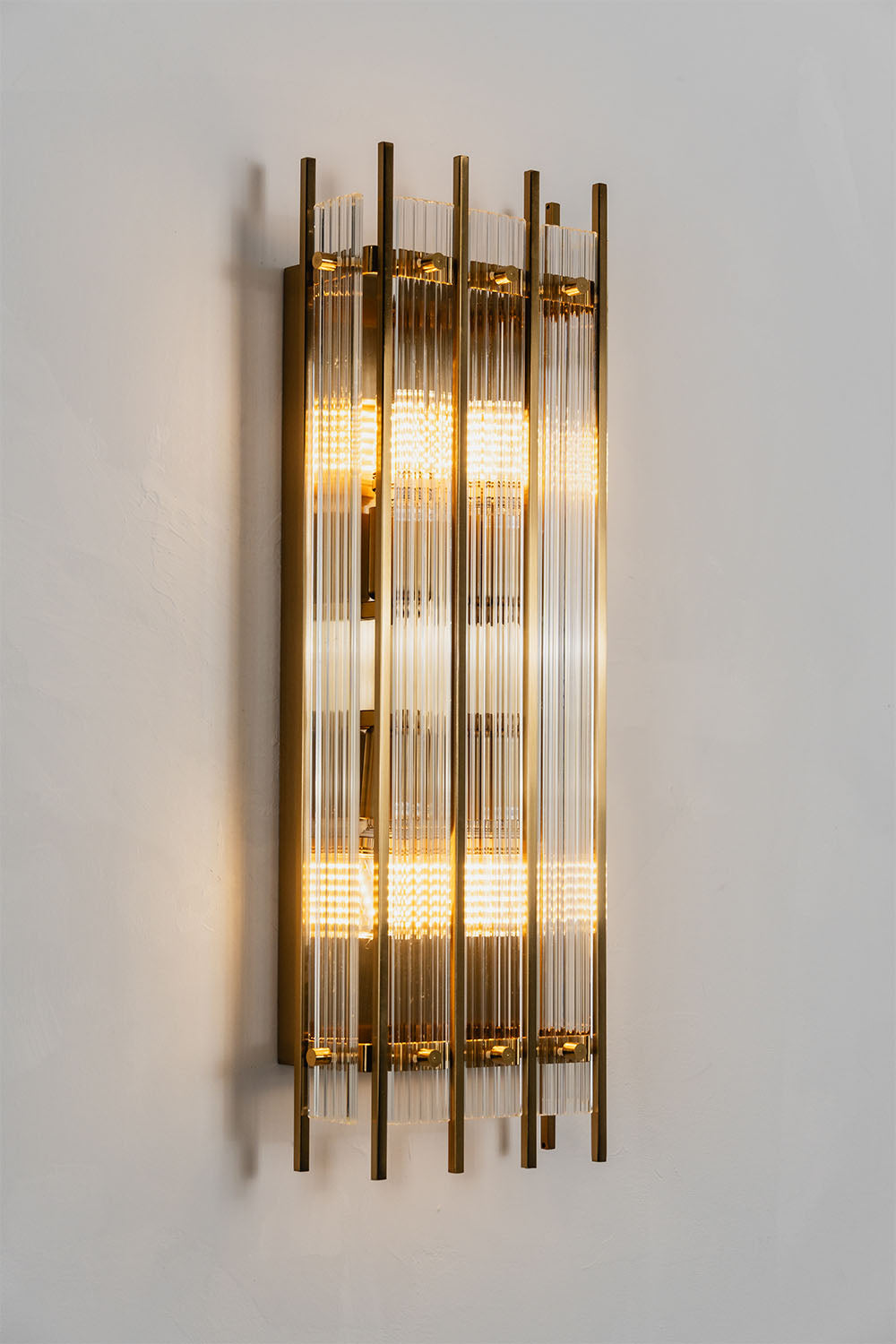 Drystan Ribbed Glass Brass Wall Lamp showcasing elegant ribbed glass and brass accents.