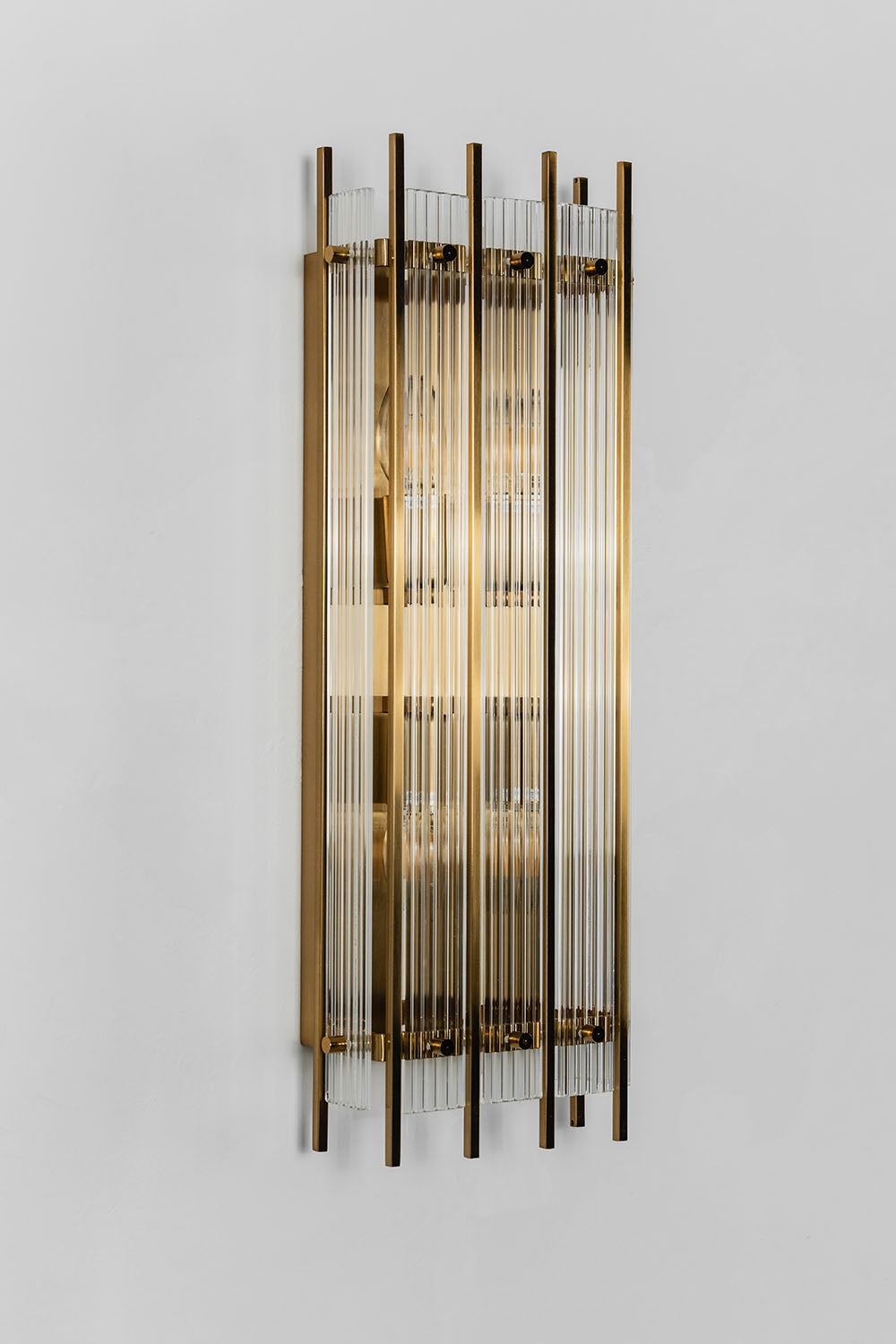 Drystan Ribbed Glass Brass Wall Lamp illuminating modern interior with elegant design.