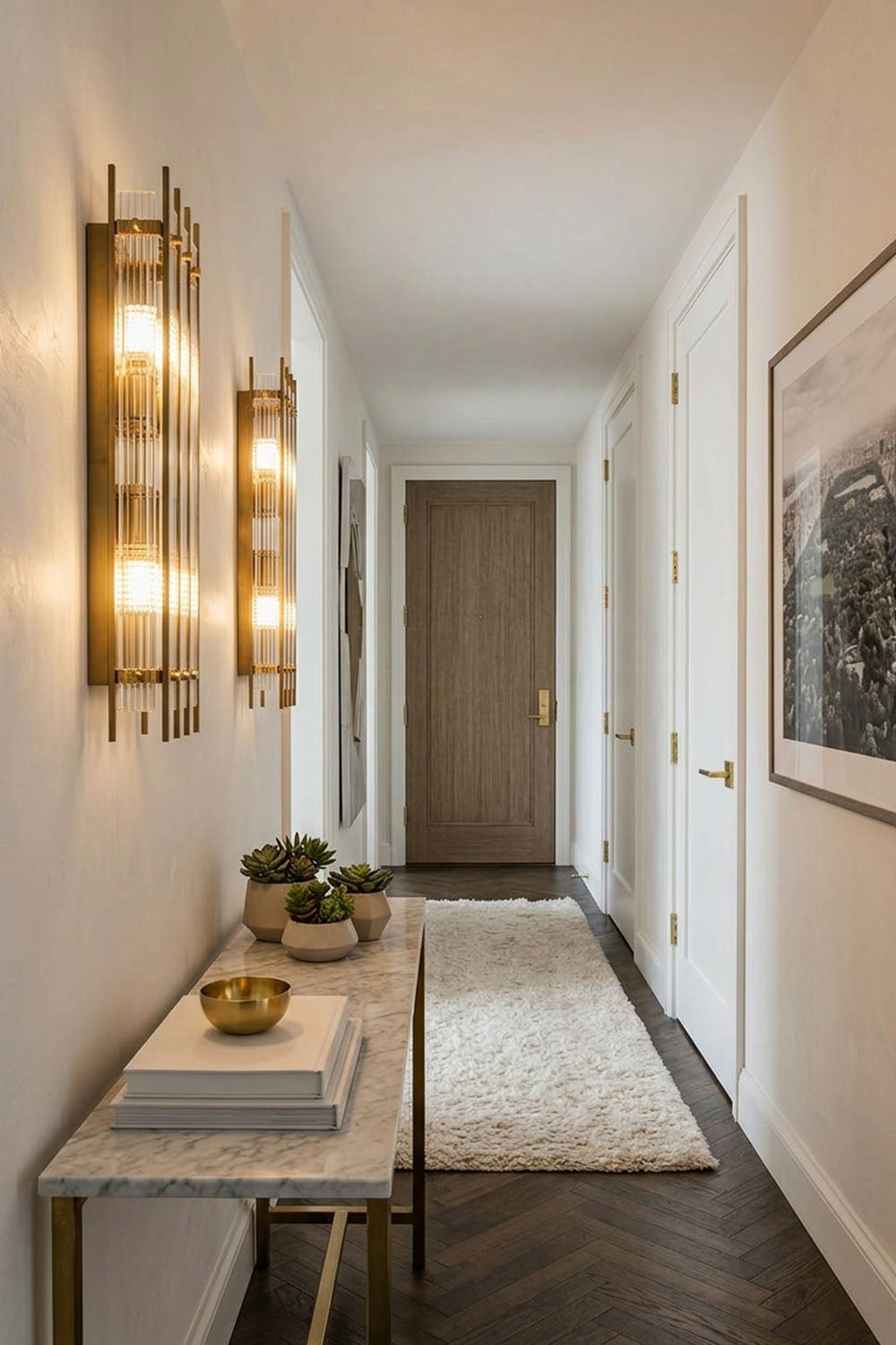 Drystan Ribbed Glass Brass Wall Lamp illuminating a stylish hallway with a marble table decor and modern design.