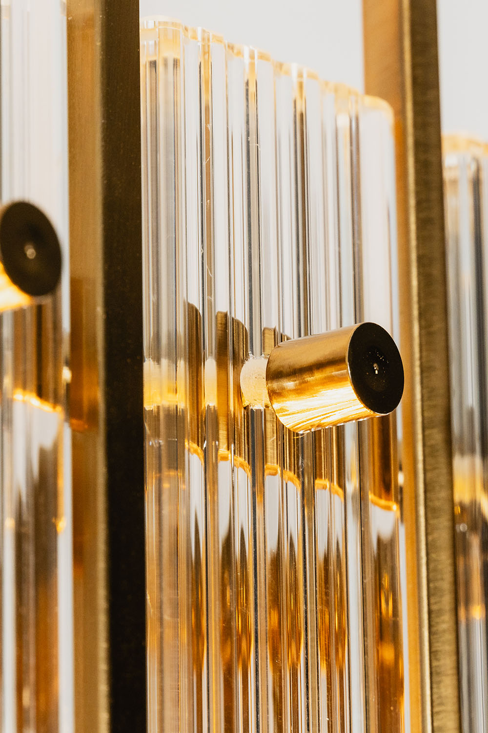 Close-up of the Drystan Ribbed Glass Brass Wall Lamp showcasing the crystal texture and brass accents.