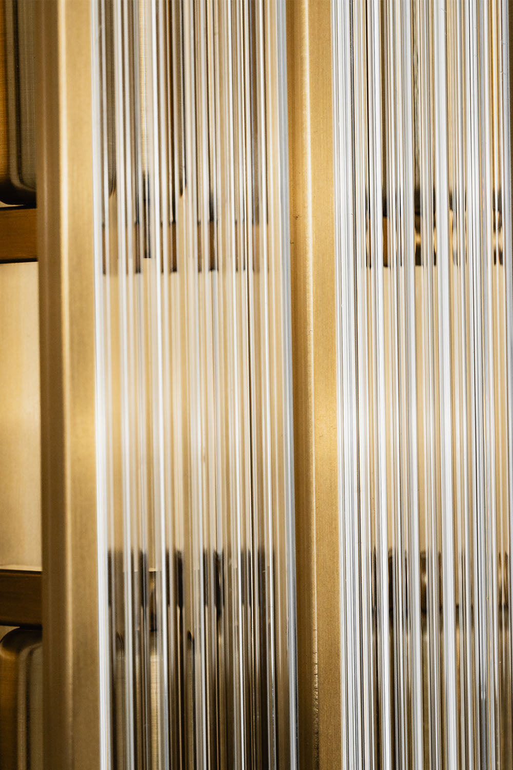 Drystan Ribbed Glass Brass Wall Lamp showcasing a detailed close-up of the ribbed glass and brass elements.
