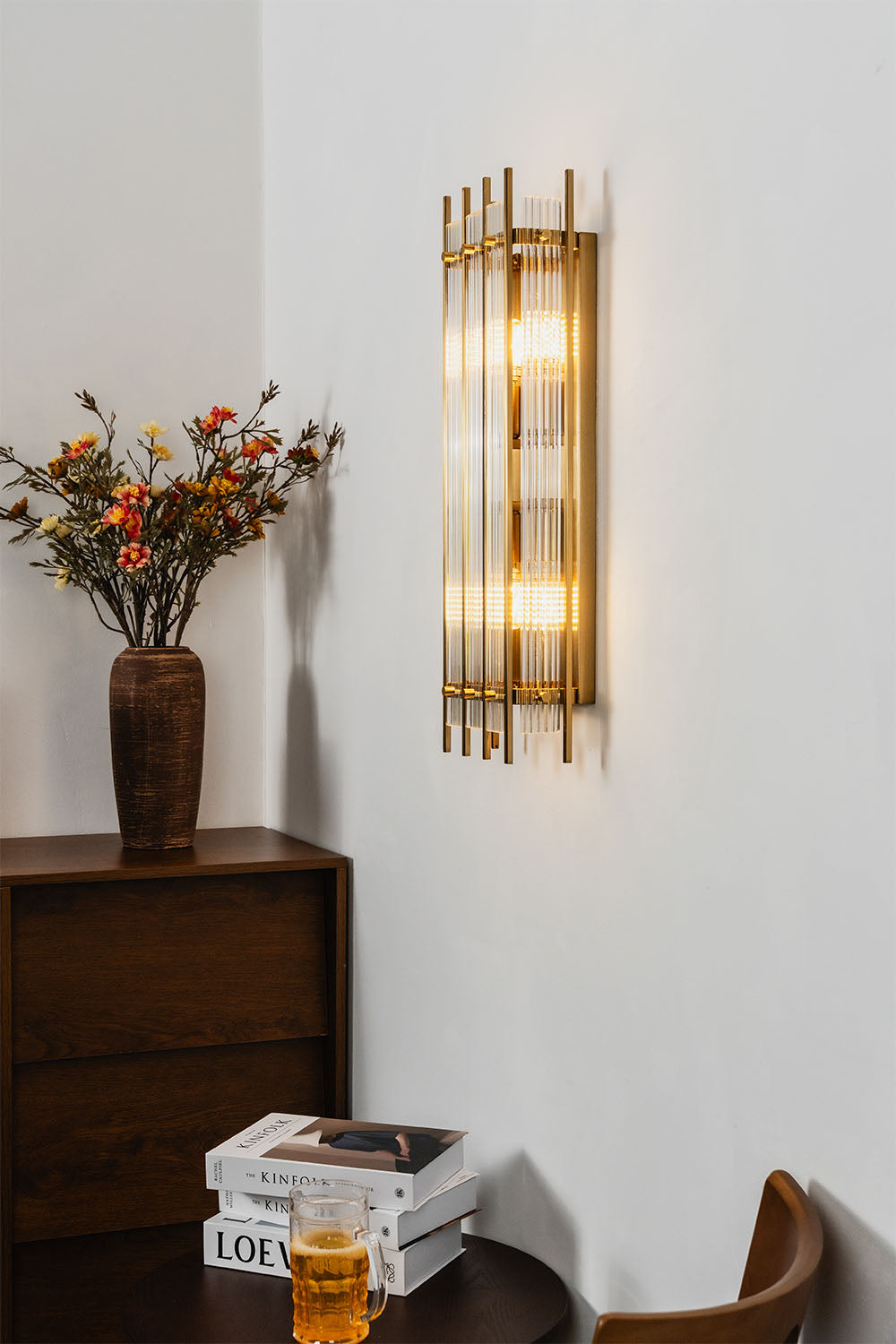 Drystan Ribbed Glass Brass Wall Lamp illuminating a cozy space with a stylish design and warm tones.
