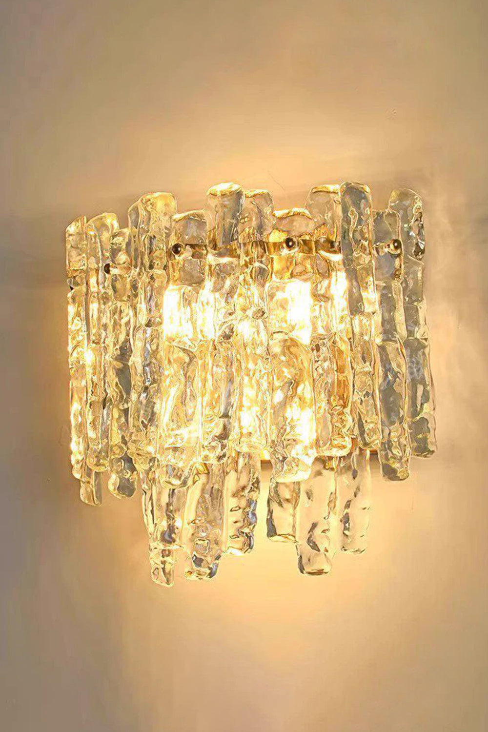 Elara Textured Cast Glass Wall Lamp | Textured Cast Glass, Polished Brass | Fully illuminated view, showing the mesmerizing, undulating, and warm light pattern cast onto the adjacent wall, illustrating its dynamic visual effect | Samu Lamp