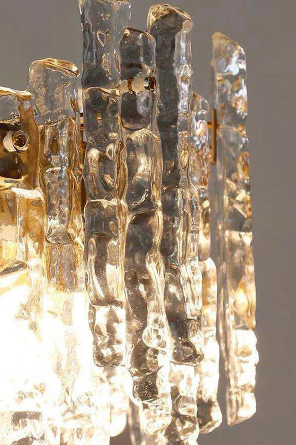 Elara Textured Cast Glass Wall Lamp | Textured Cast Glass, Polished Brass | Extreme close-up detail macro shot focusing on the rough, flowing texture and multi-faceted patterns of the unique, artisanal cast glass panels | Samu Lamp