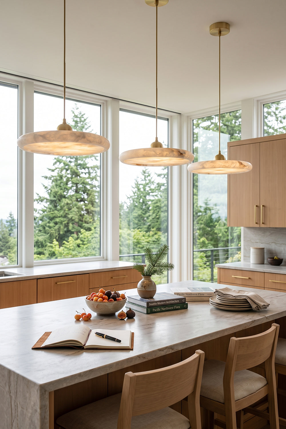 Elowen Alabaster Disc Pendant Light| Natural Alabaster and Brass | Suspended in a row over an indoor dining table against a wall of bright floor-to-ceiling windows | Samu Lamp