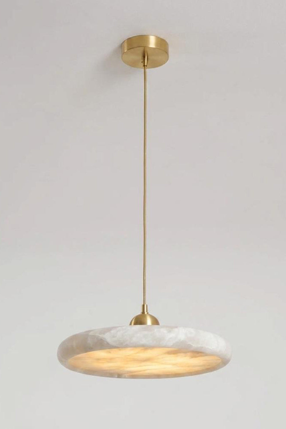 Elowen Alabaster Disc Pendant Light | Natural Alabaster and Brass | Standard studio product view hanging from a gold ceiling canopy against a light neutral background | Samu Lamp