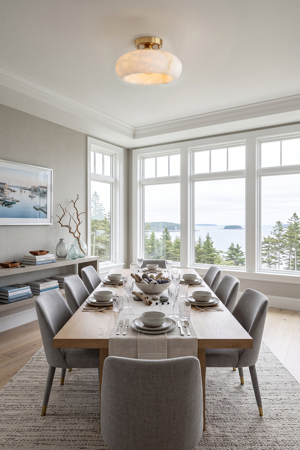 Elowen Alabaster Semi-Flush Ceiling Light illuminating a dining room with large windows and a scenic view.