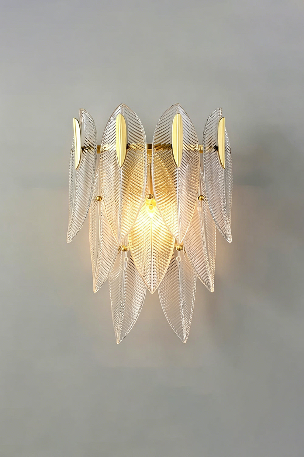 Elowen Cascading Glass Wall Lamp | Glass, Metal | Studio front view of the fully illuminated tiered glass fixture casting a warm, romantic ambient light halo on a grey backdrop | Samu Lamp
