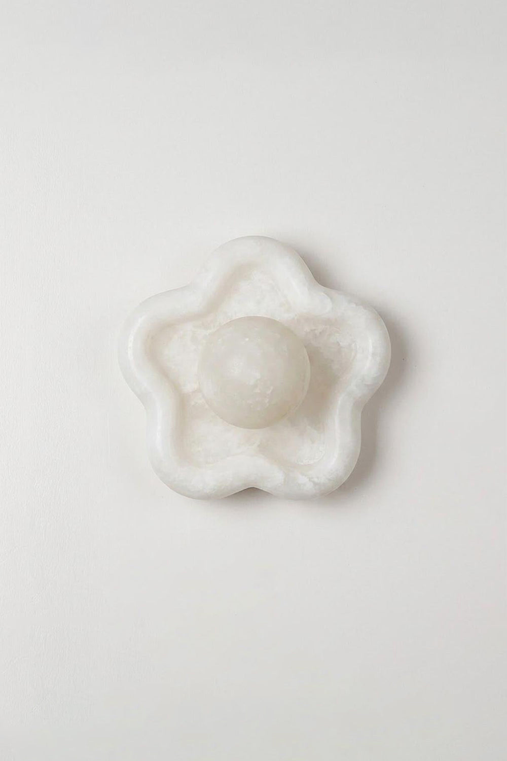 Elowen Petal Alabaster Wall Sconce | Natural Alabaster | Studio product presentation showing the unlit floral stone fixture hanging on a plain light wall | Samu Lamp