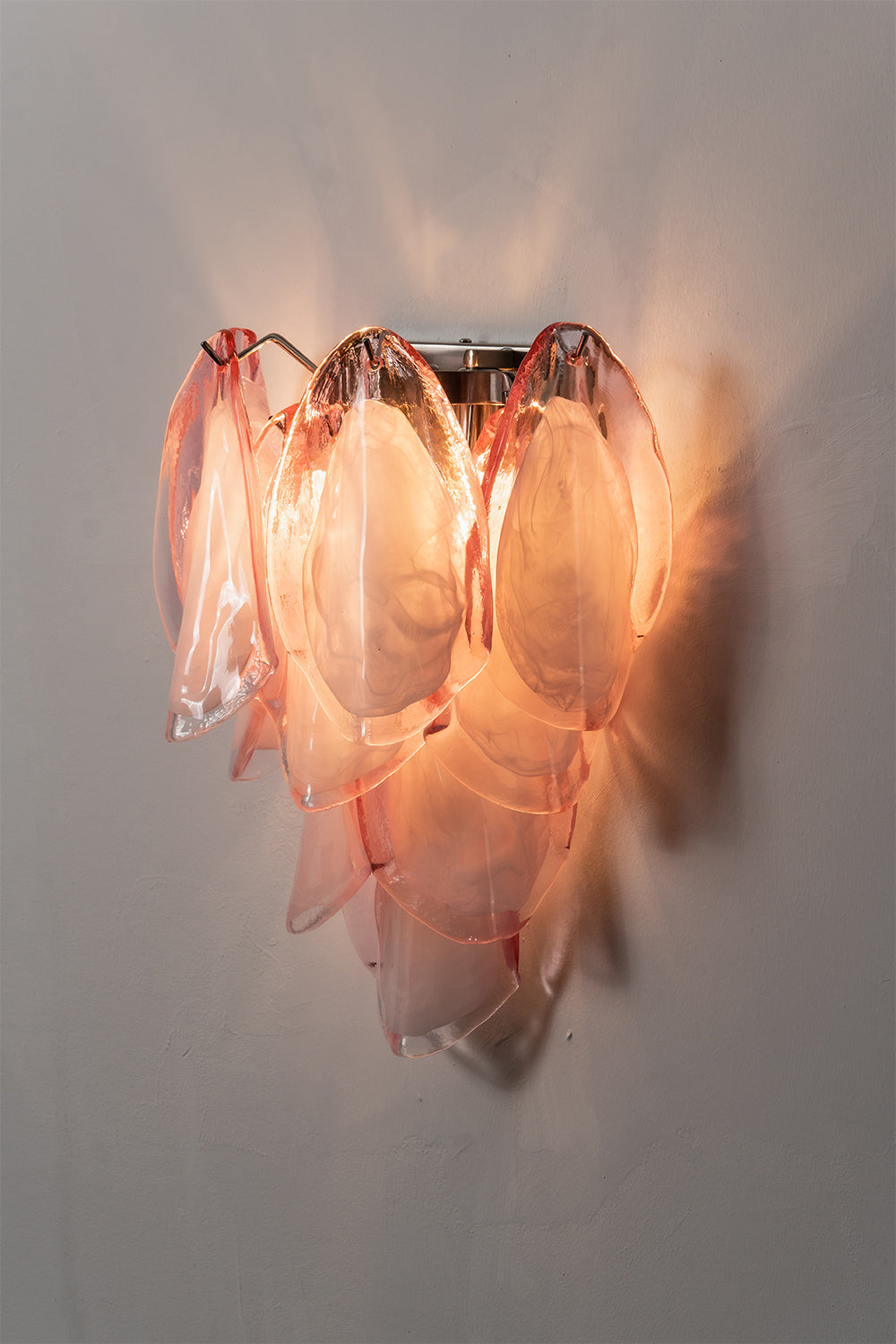 Elysian Bloom Glass Wall Lamp | Metal, Glass | Frontal view of the fully lit lamp casting a warm pink and golden glow on the wall | Isolated shot | Samu Lamp