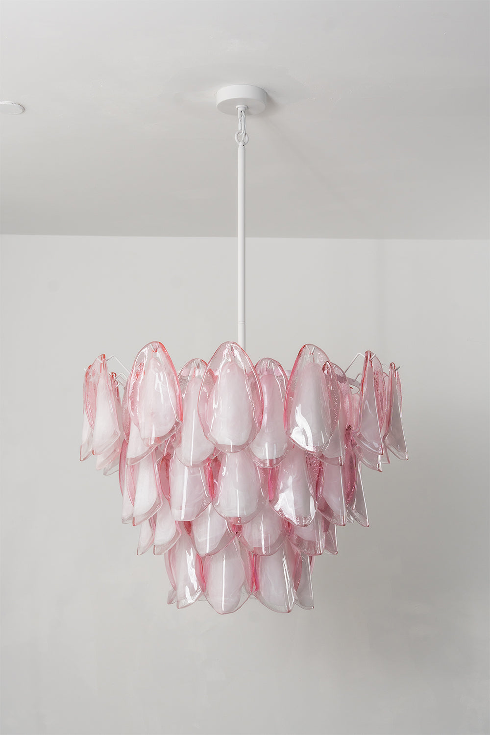 Elysian Bloom Rose Glass Chandelier | Metal, Glass | Frontal view of the unlit chandelier against a plain wall, highlighting the pink glass texture | Isolated shot | Samu Lamp