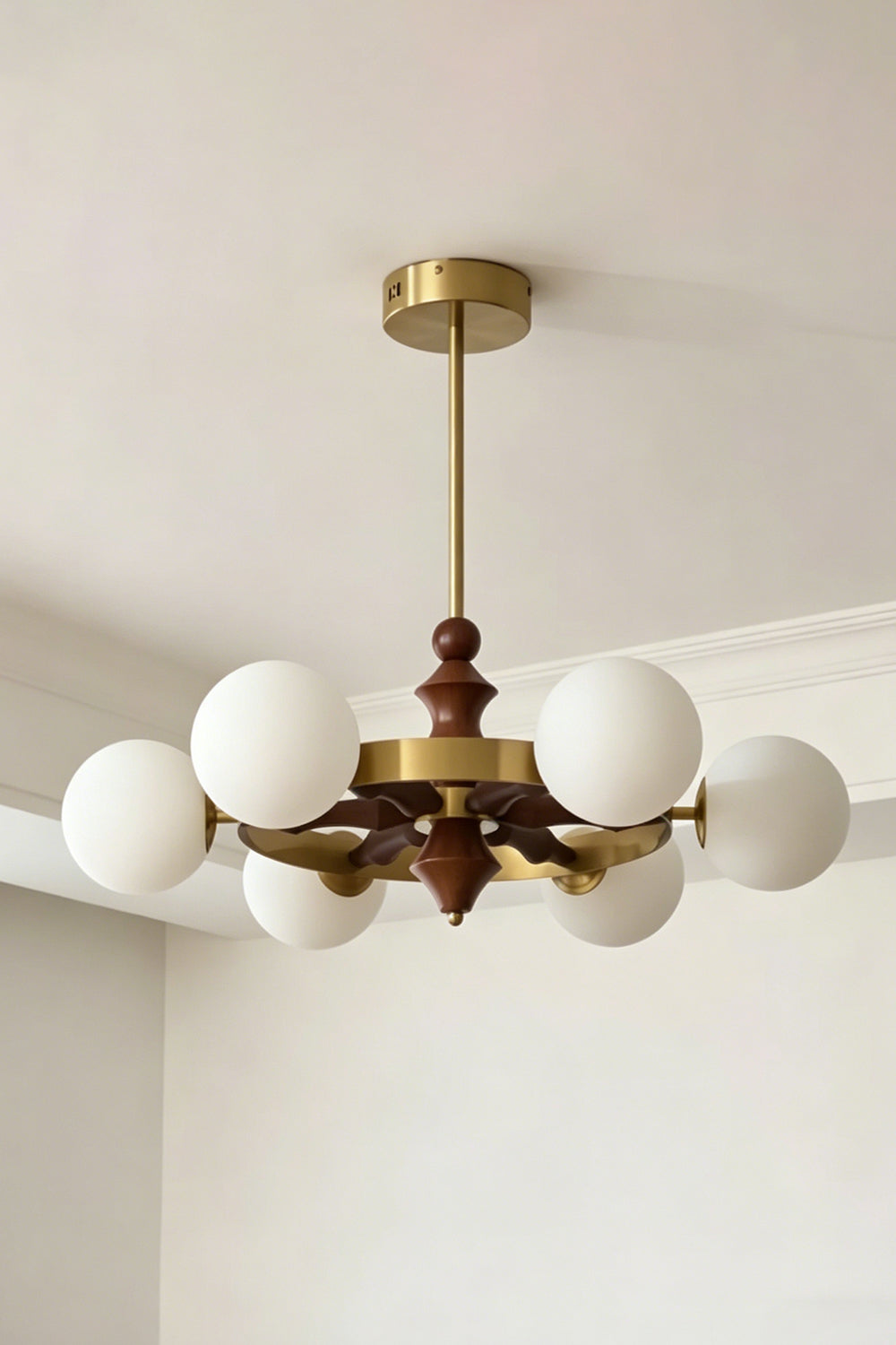 Lit white glass globe version of the Elysian Circlet Chandelier | Metal, Glass, Wood | Perspective view against a neutral wall | Samu Lamp