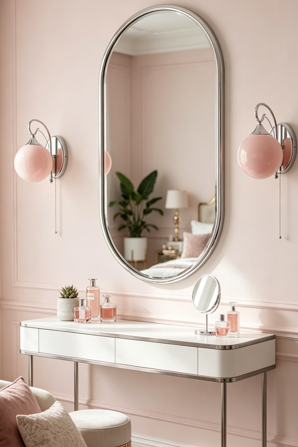Pair of pink glass globe sconces | Metal, Glass | Vanity flanking oval mirror in soft pink room | Samu Lamp