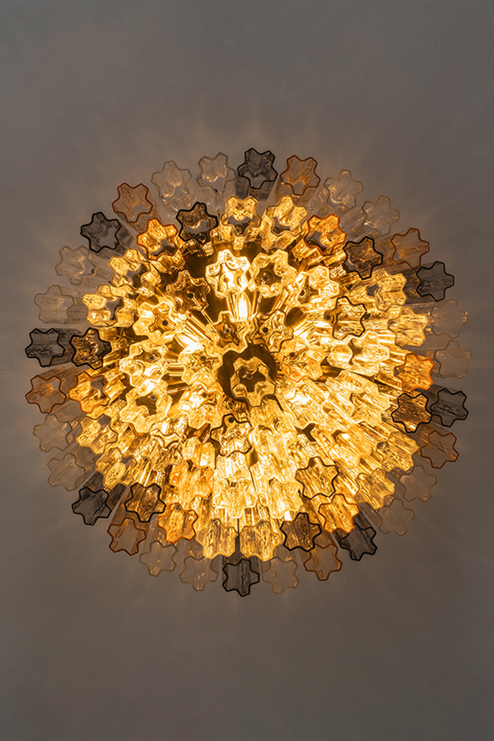 Elysian Tiered Fluted Ceiling Light | Glass, Metal | Direct bottom-up perspective view looking into the glowing radial concentric tiers of fluted glass rods | Detail shot | Samu Lamp