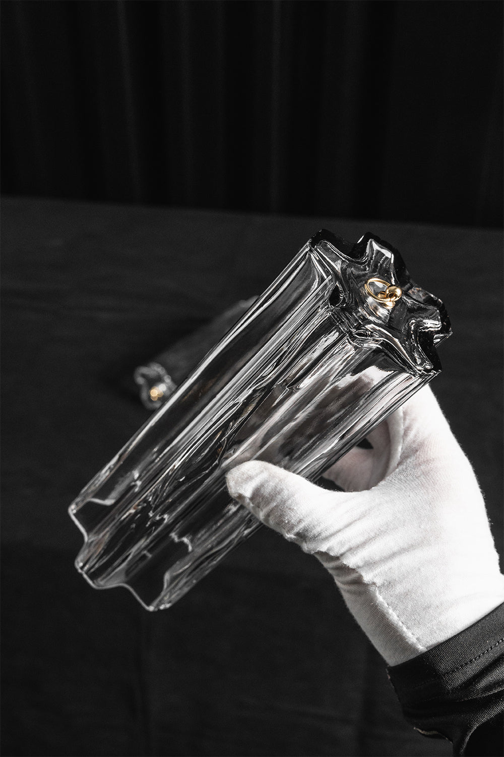 Elysian Tiered Fluted Ceiling Light | Glass, Metal | A gloved hand holding a single molded rectangular wave-shaped clear glass rod component to demonstrate its profile and size | Detail shot | Samu Lamp