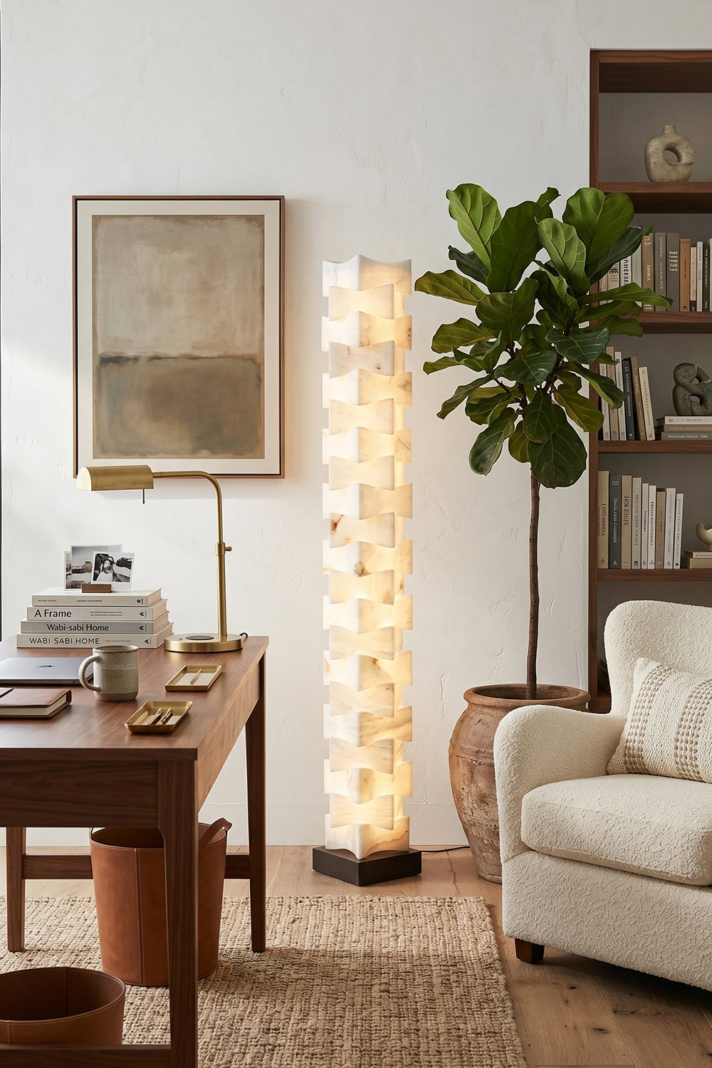 Ethereal Monolith Alabaster Floor Lamp | Lit in rustic modern workspace corner | Desk with chair and Fiddle Leaf Fig | Near a white couch with abstract art | Samu Lamp