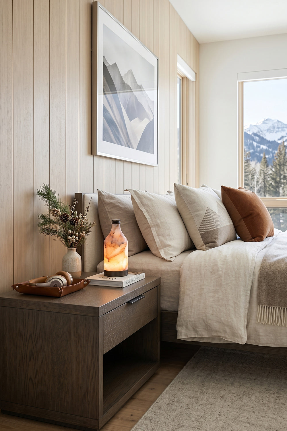 Evander Alabaster Bottle Table Lamp | Alabaster, Metal | Styled on a sleek dark bronze bedside storage cabinet in a contemporary bedroom suite looking out onto snowy mountain peaks | Samu Lamp