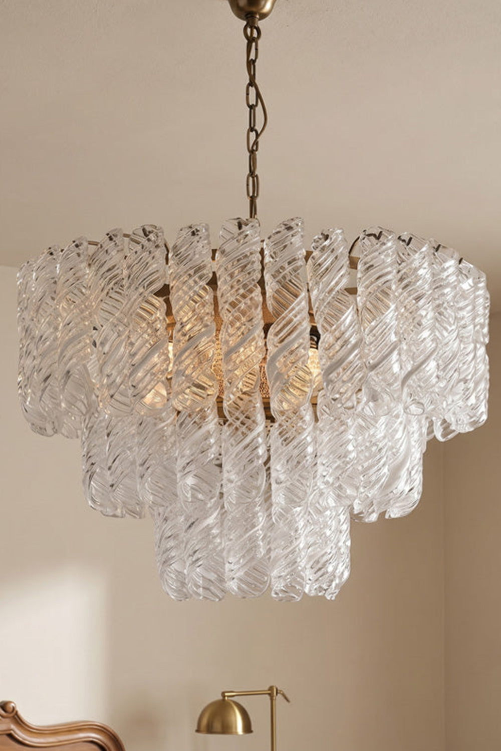 Evangeline Tiered Twisted Glass Chandelier | Studio Hanging View | Full-length studio presentation of the cascading tiered glass pendant lamp fixture hanging against a plain wall | Samu Lamp