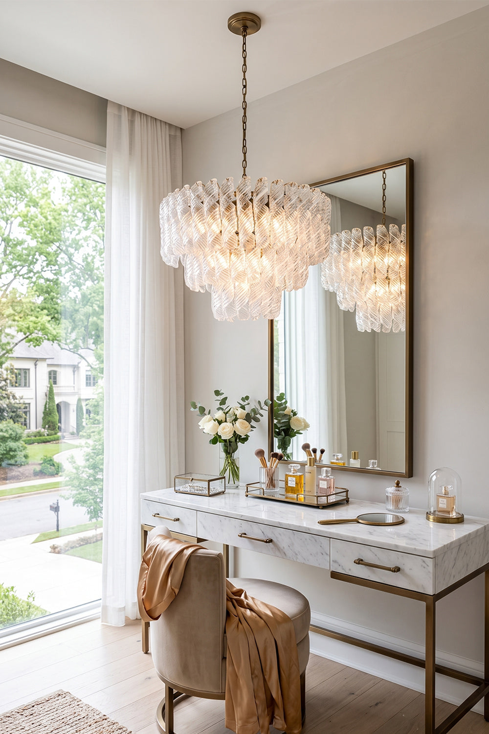 Evangeline Tiered Twisted Glass Chandelier | Dressing Room Decor | Radiating a soft ambient glow next to a white vanity dressing table with a large mirror in a sunlit residential space | Samu Lamp