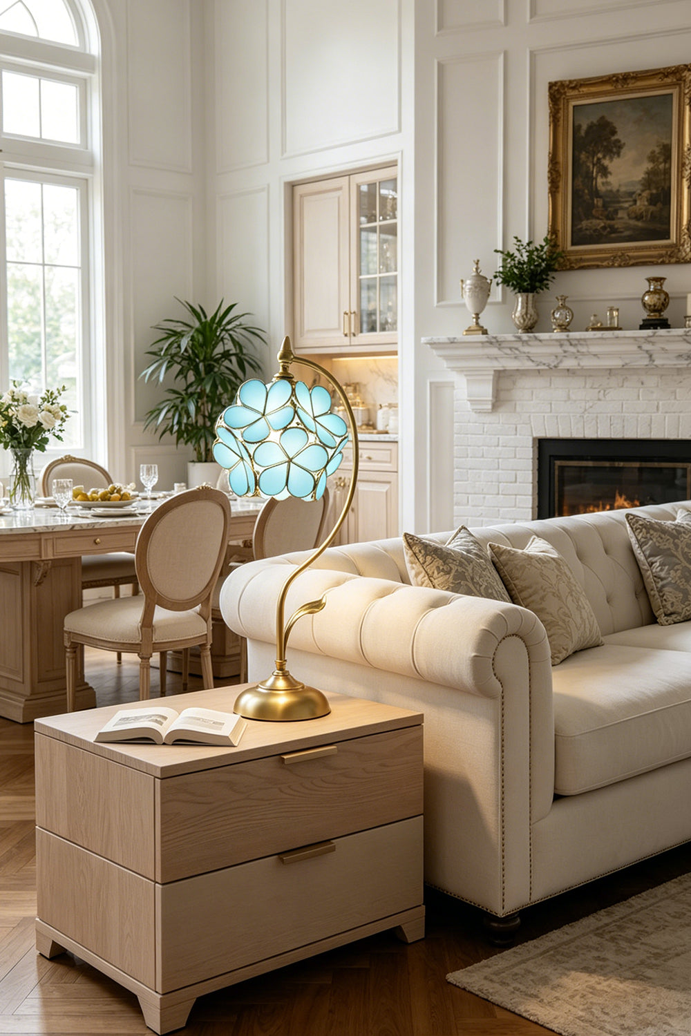 Evanthe Blossom Stained Glass Table Lamp | Stained Glass, Metal | Blue variant illuminating a cozy modern living room setup from a light beige side table next to a plush cream sofa | Samu Lamp