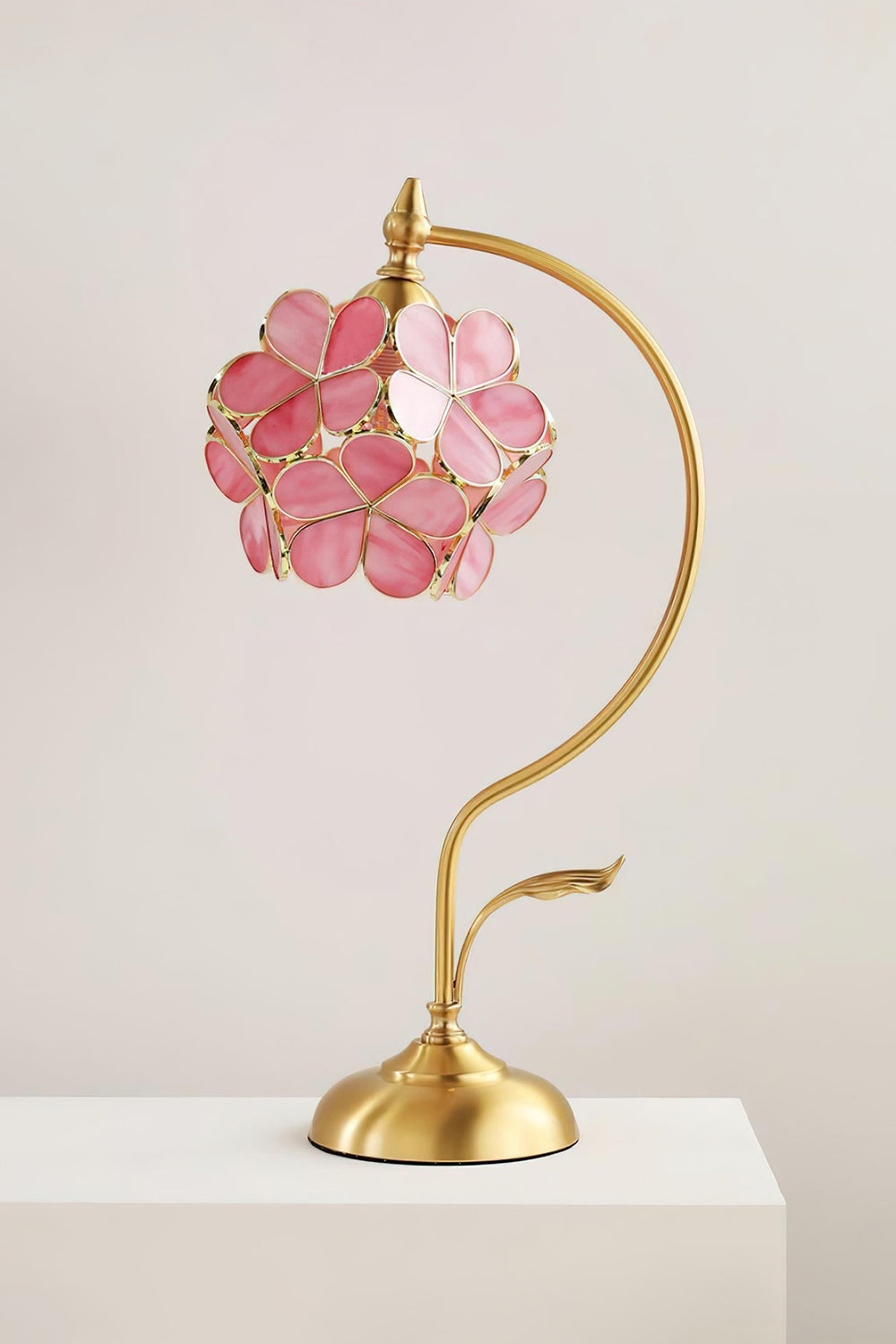 Evanthe Blossom Stained Glass Table Lamp | Stained Glass, Metal | Front view of the fully lit pink blossom table lamp displayed elegantly on a clean white pedestal backdrop | Samu Lamp