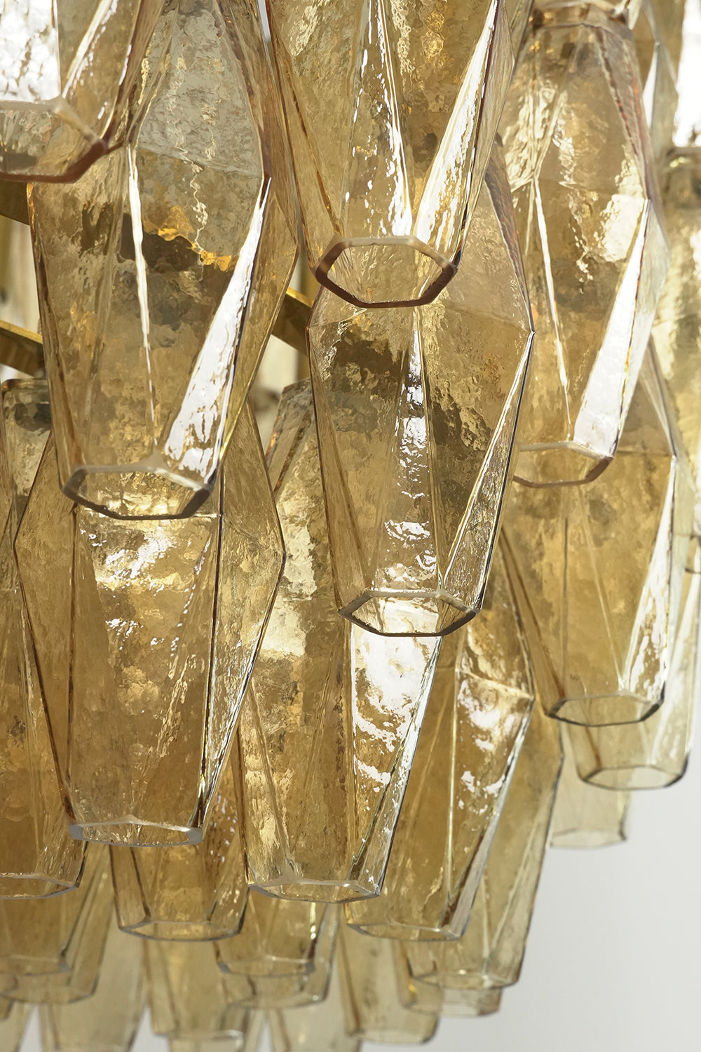 Close-up of unlit faceted amber glass prisms | Glass | Detailed view of the textured glass surface | Samu Lamp