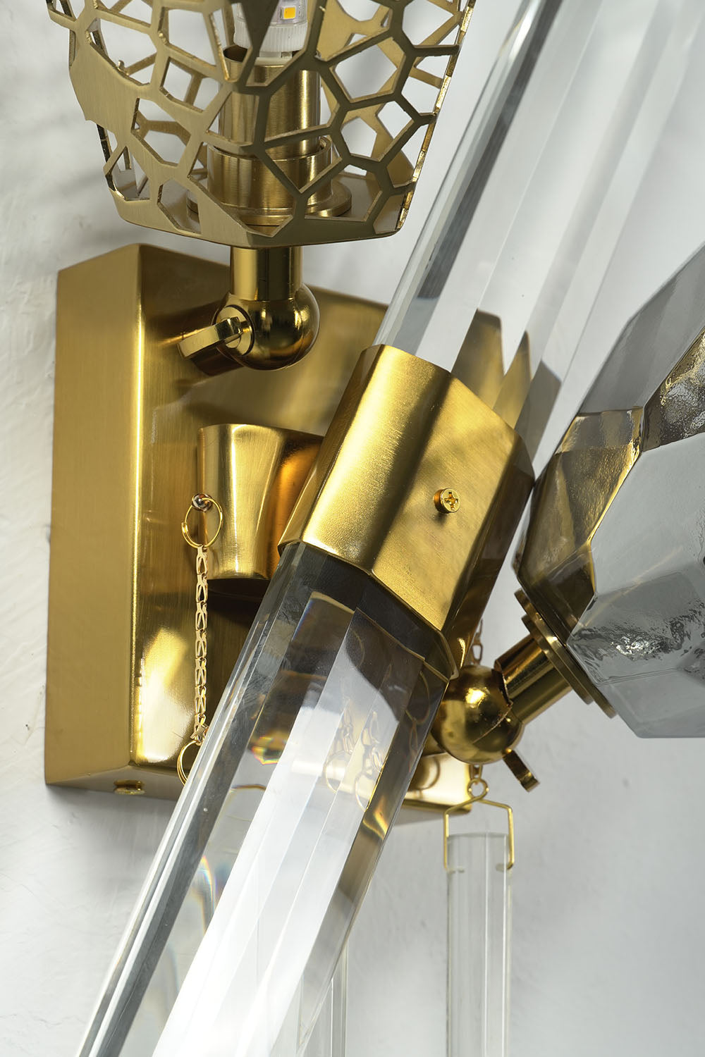 Faucenne Pierced Shade Crystal Spear Wall Lamp | Cut Crystal and Brass | Close-up detail view of the brass mounting hardware and crystal spear | Samu Lamp