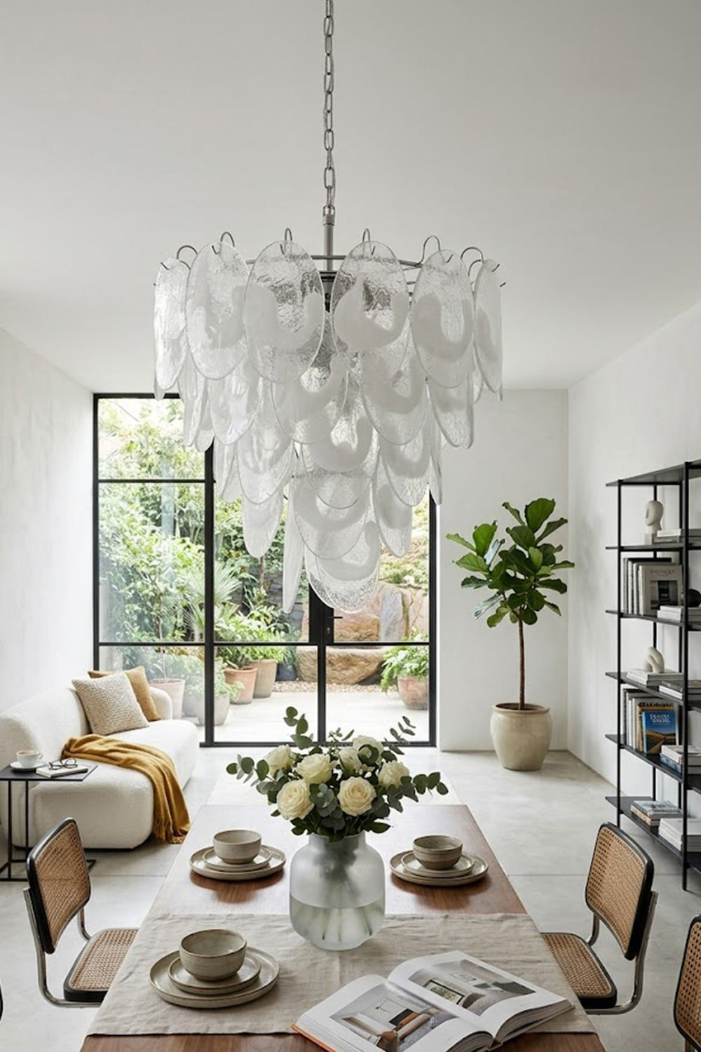 Glass leaf cluster chandelier over a set dining table | Metal, Glass | Centered in a modern dining room with chairs | Samu Lamp