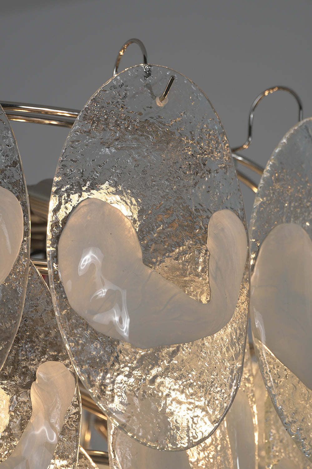 Close-up of lit glass leaves on the Frostelle chandelier | Glass | Detail shot showing light through textured glass | Samu Lamp