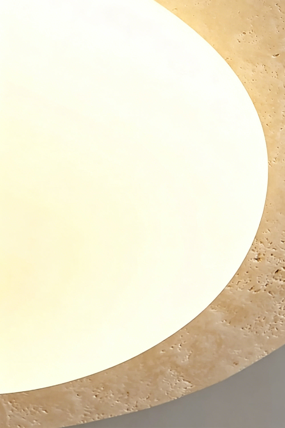 Travertine Ceiling Light Detail | Travertine, Glass | Extreme close-up of lit stone halo edge | Emphasizing the natural voids and texture | Samu Lamp
