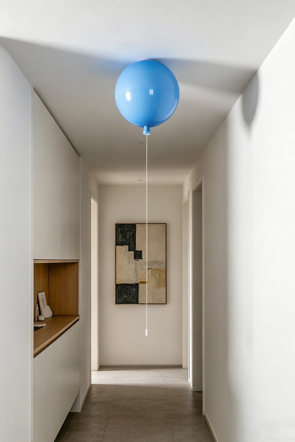 Glass Balloon Ceiling Light illuminating a modern hallway with a blue hand-blown glass orb fixture.