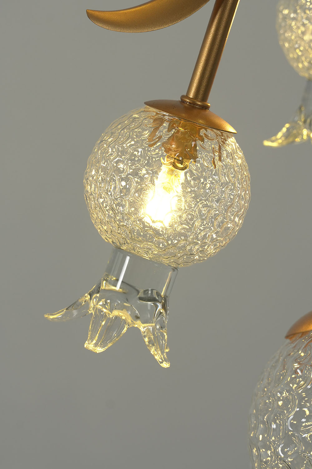 Grenaline Vine Chandelier | Textured Glass and Brass | Lit macro close-up of glowing pomegranate globe | Samu Lamp