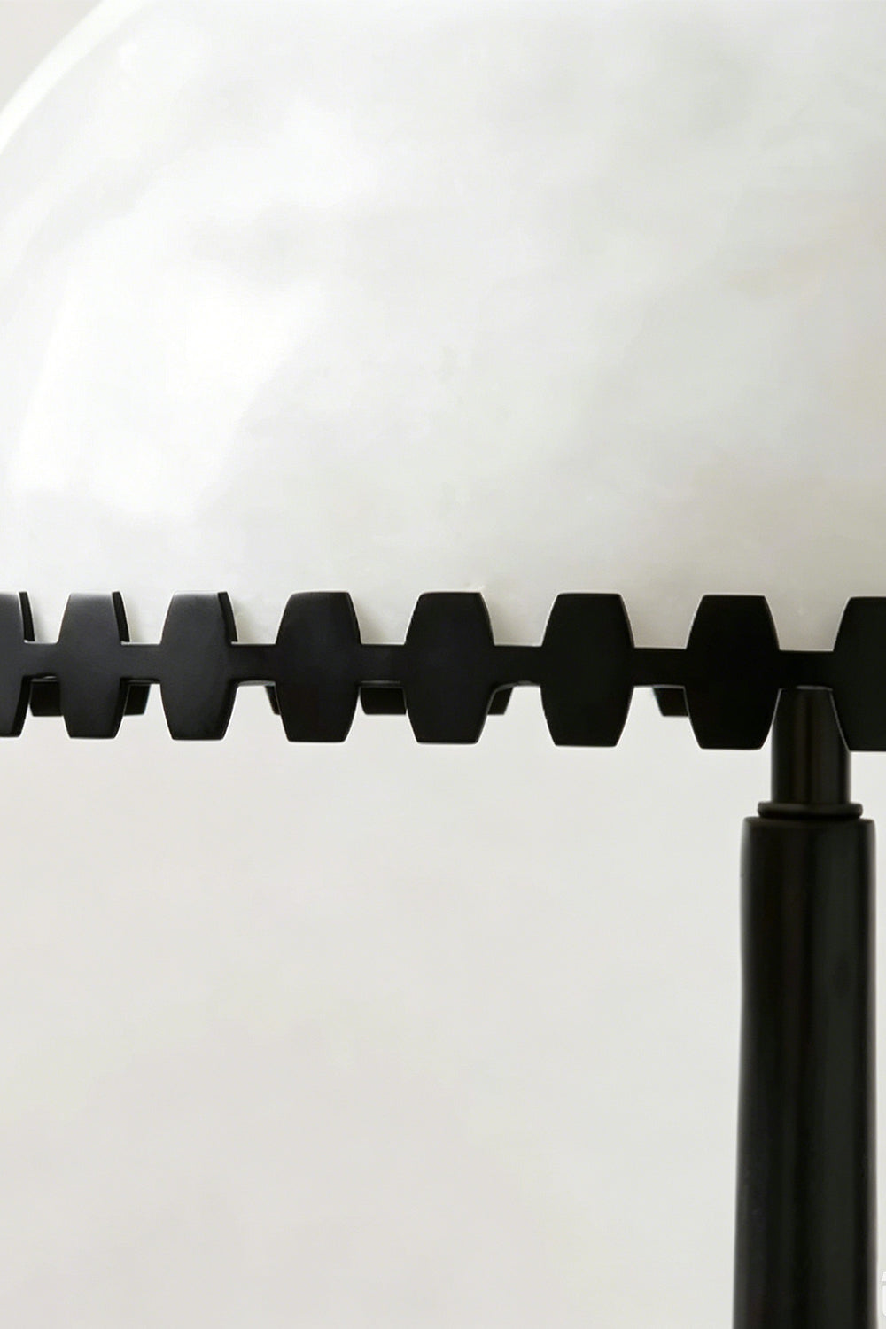 Helena Alabaster Trim Table Lamp | Notched Trim Detail | Macro close-up focus highlighting the unique serrated geometric black metal trim bordering the white translucent alabaster shade | Detail shot | Samu Lamp