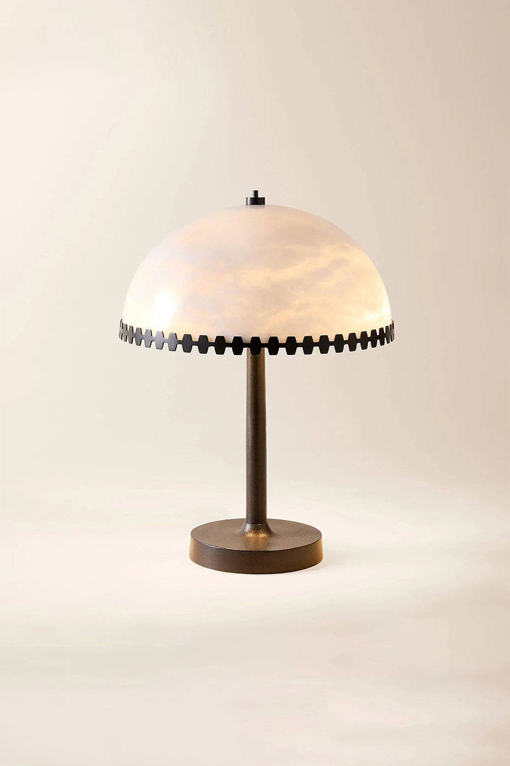 Helena Alabaster Trim Table Lamp | Studio Lit View | Studio front view of the fully lit dome-shaped stone table lamp resting on a light beige backdrop under warm lighting | Samu Lamp