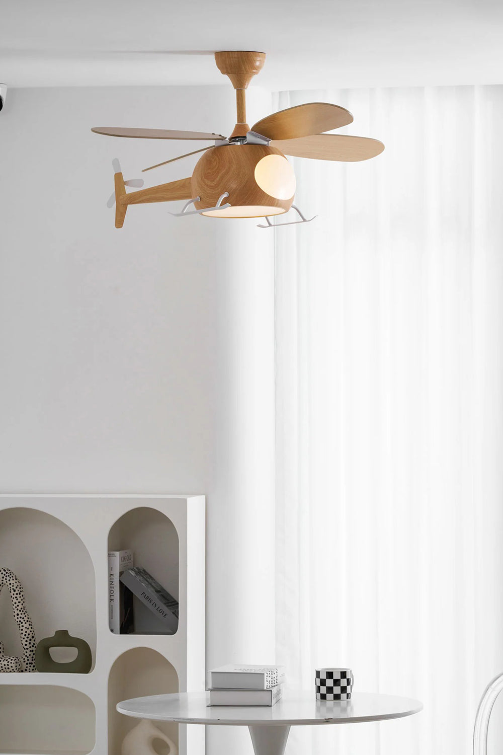 Heli Breeze Helicopter Ceiling Fan Light | Wood, Metal | Positioned as a whimsical ceiling light fixture in a bright kids nursery playroom next to a white arched shelving unit | Samu Lamp