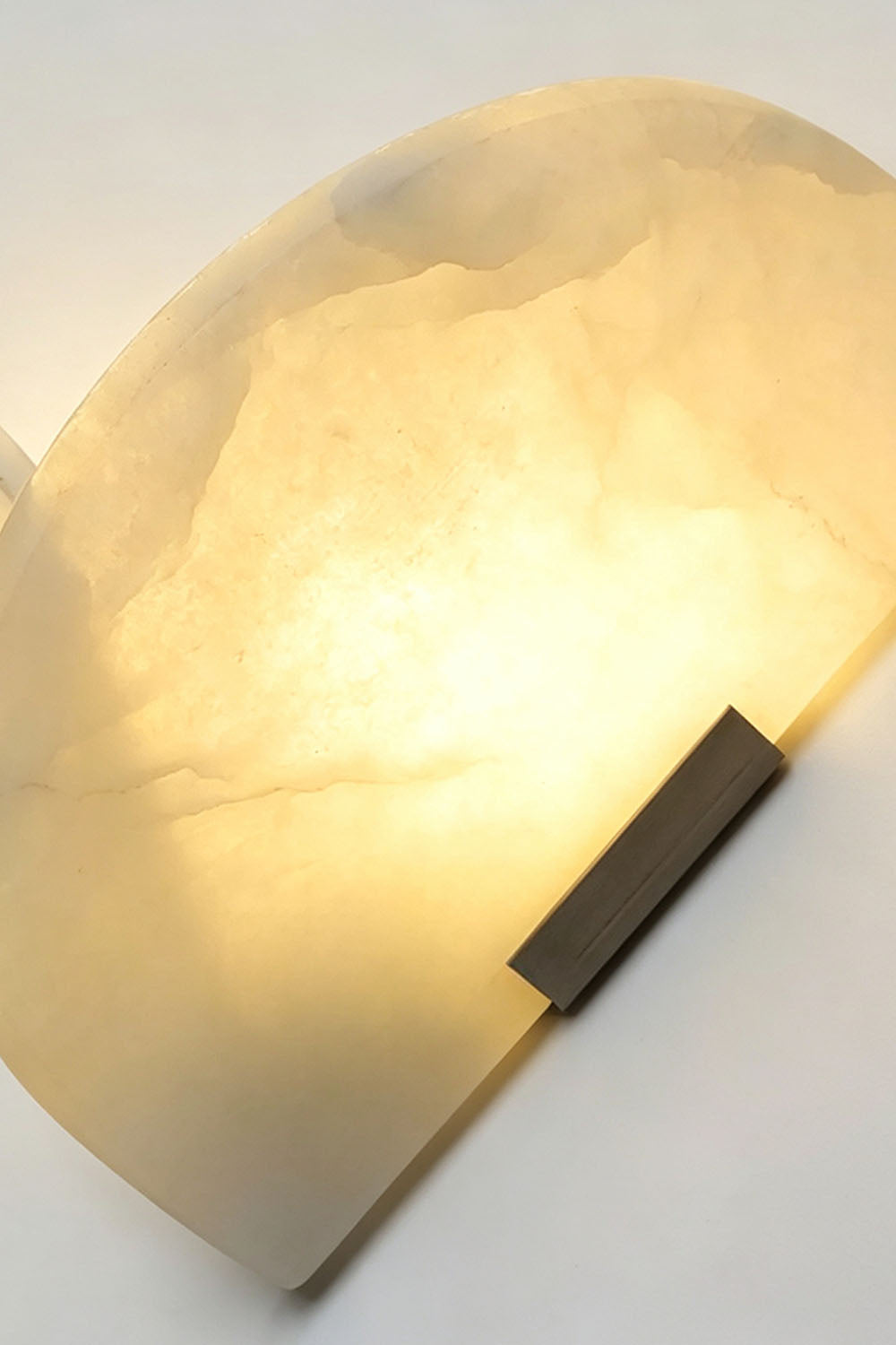 Hollis Angled Alabaster Wall Lamp | Natural Alabaster and Metal | Close-up detail of the illuminated alabaster shade and natural stone grain | Samu Lamp