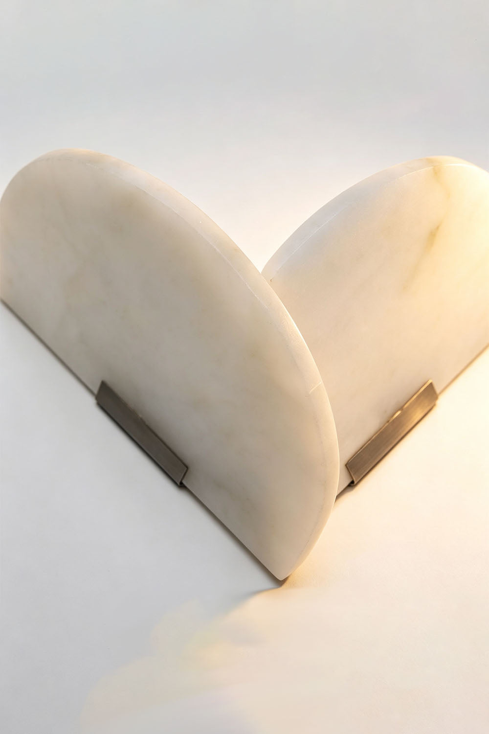 Hollis Angled Alabaster Wall Lamp | Natural Alabaster and Metal | Detail perspective shot highlighting the central metal bracket and angled shades | Samu Lamp